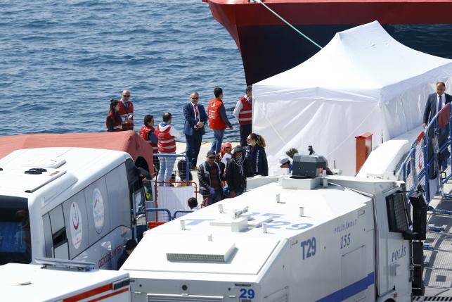 Migrants are escorted by Turkish police officers as they arrive in the Turkish coastal town of Dikili