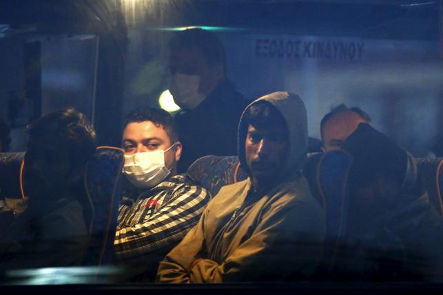 Migrants are seen on a bus before boarding a Turkish-flagged passenger boat to be returned to Turkey, on the Greek island of Lesbos