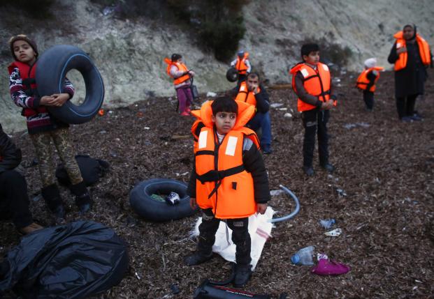 Migrant children wearing life jackets wait for a dinghy to sail off for the Greek island of Lesbos from the Turkish coastal town of Dikili