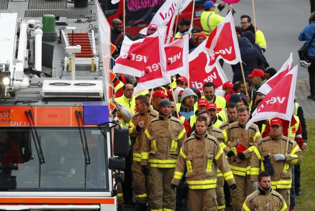 Firefighters, members of Verdi union, march during a strike near Frankfurt airport