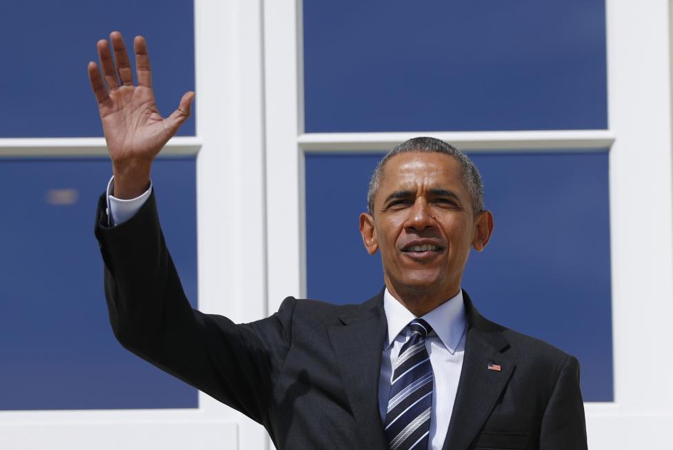U.S. President Obama waves from the balcony before proceeding to bilateral talks at Schloss Herrenhausen in Hanover