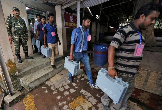 Election officials carry EVM as they arrive to count votes in the West Bengal Assembly elections, at a counting center in Kolkata