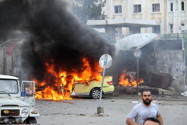 People inspect the damage after explosions hit the Syrian city of Tartous