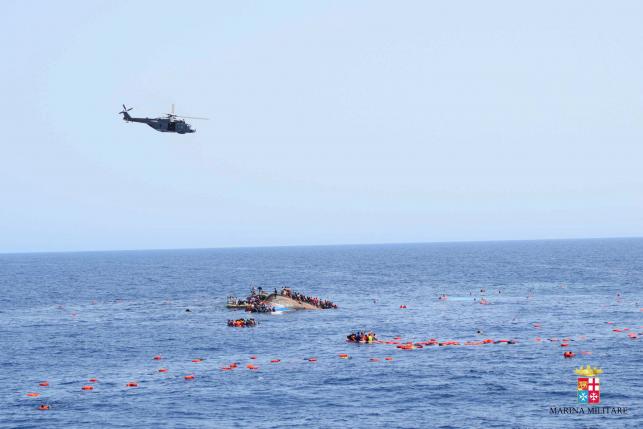 Migrants from a capsized boat are rescued during a rescue operation by Italian navy ships "Bettica" and "Bergamini" off the coast of Libya