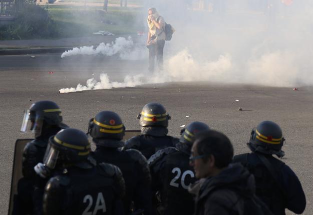 French CRS riot police secure a position as clouds of tear gas fill the Place de la Nation during clashes with youths who protest against the French labour law proposal during the May Day labour union march in Paris