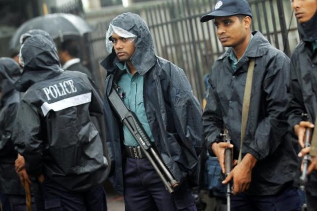 Police officers stand guard in front of the gate of ICT before a verdict against Bangladesh Jamaat-e-Islami chief Motiur Rahman Nizami in Dhaka