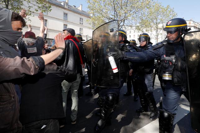 French CRS riot police use spray to push back youthsduring a protest in Paris
