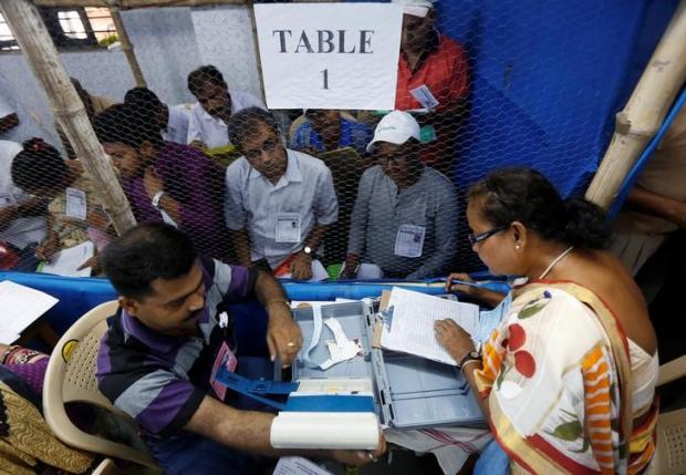 Election officials count votes in the West Bengal Assembly elections, at a counting centre in Kolkata