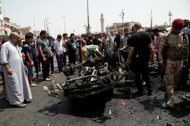 People gather at the scene of a car bomb attack in Baghdad's mainly Shi'ite district of Sadr City