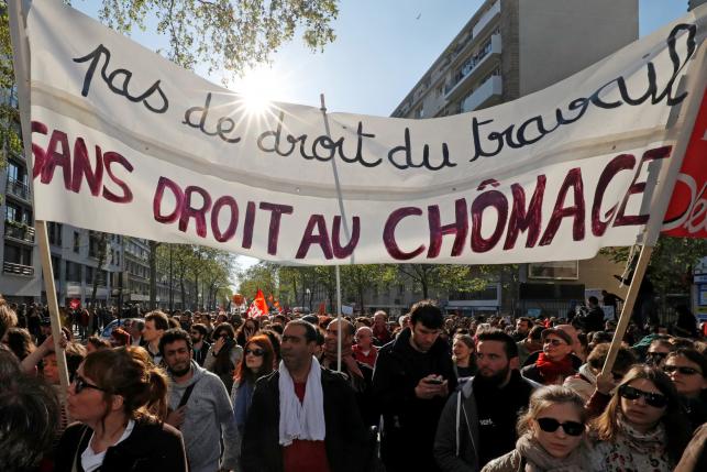 A banner reads "No right to work. No unemployment rights" protests against the French labour law proposal during the May Day labour union march in Paris, France