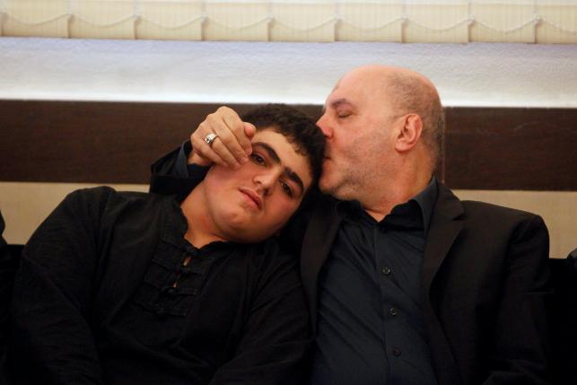 Former Hezbollah MP Amin Cherri, comforts Ali Badreddine, the son of top Hezbollah commander Mustafa Badreddine who was killed in an attack in Syria, as they accept condolences for his death in Beirut's southern suburb
