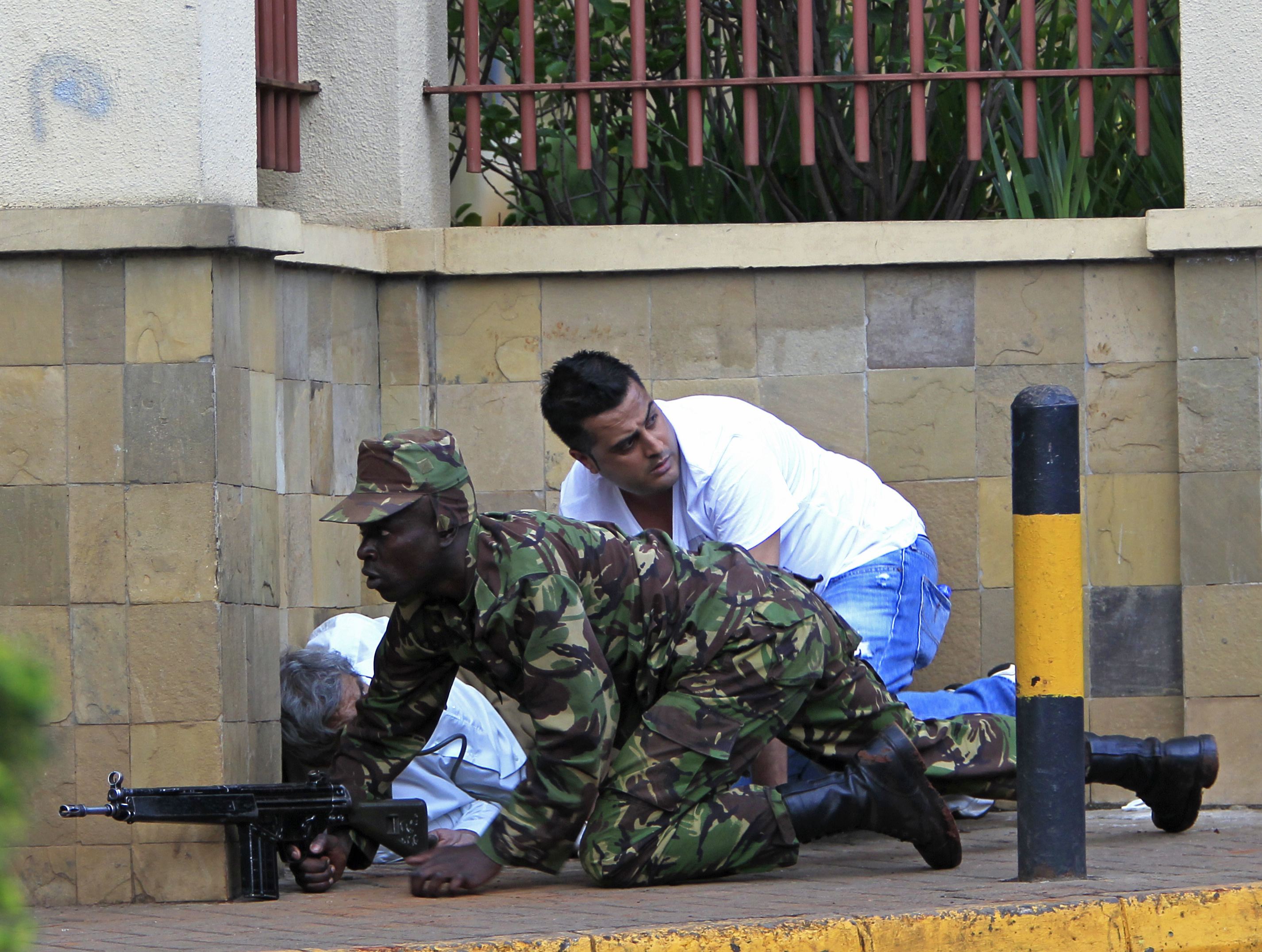 A Kenyan army soldier takes cover behind a wall at Westgate Shopping Centre in Nairobi