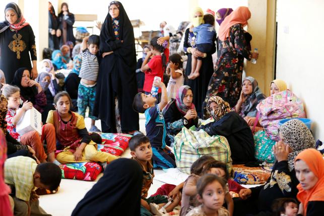 Civilians who fled their homes due to clashes on the outskirts of Falluja, gather in the town of Garma