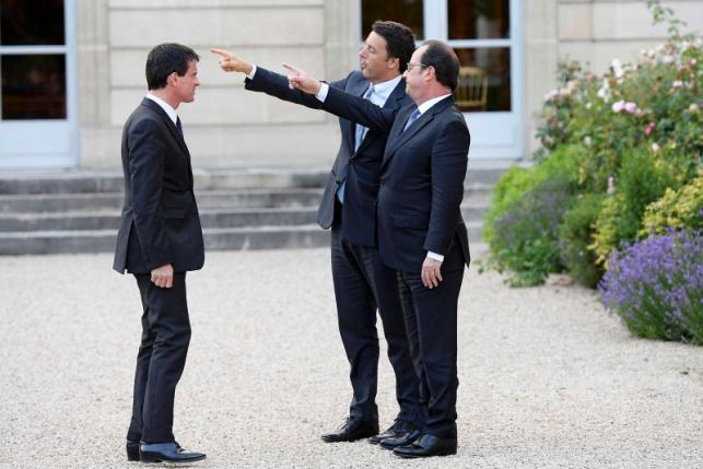 French Prime Minister Manuel Valls looks at French President Francois Hollande and Italy's Prime Minister Matteo Renzi point as they visit the gardens at the Elysee Palace in Paris