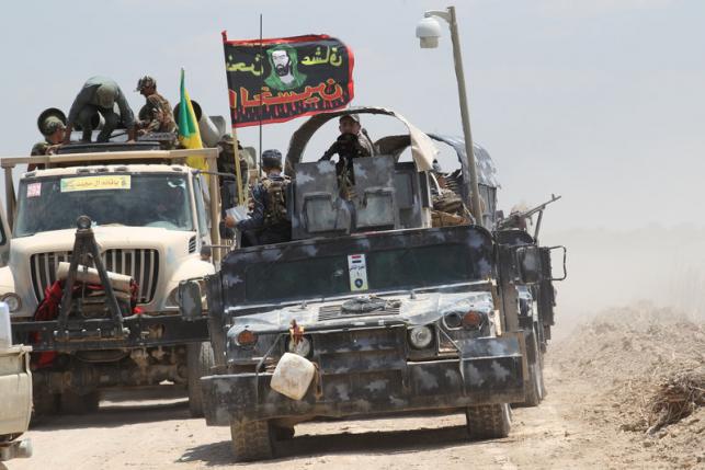 Iraqi security forces and Shi'ite fighters sit in military vehicles near Falluja