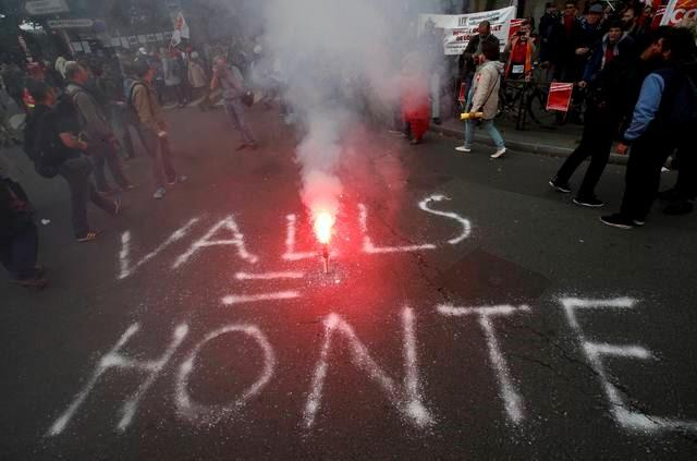 The message "Valls = shame", in reference to French Prime Minister Manuel Valls, is seen on the road during a demonstration in Paris