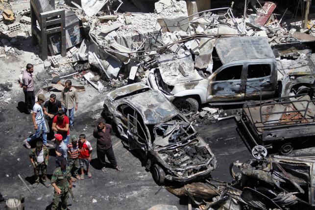 People and Syrian Army members inspect a damaged site after a suicide and car bomb attack in south Damascus Shi'ite suburb of Sayeda Zeinab