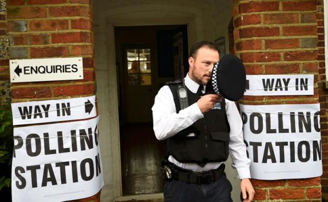 A policeman stands outside a polling station in Biggin Hill