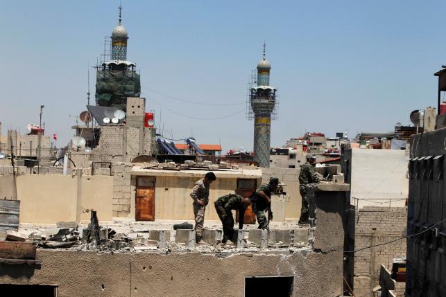 Syrian Army members inspect a damaged roof near Sayeda Zeinab mosque minarets after a suicide and car bomb attack in south Damascus Shi'ite suburb of Sayeda Zeinab