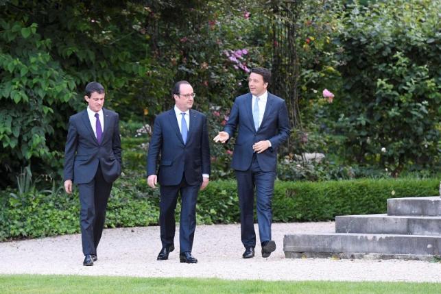 French Prime Minister Manuel Valls, French President Francois Hollande and Italy's Prime Minister Matteo Renzi walk in the gardens at the Elysee Palace in Paris