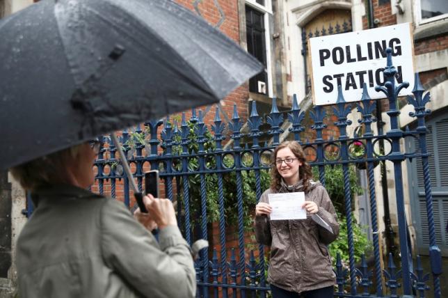 A woman photographs her daughter after she voted at a polling station for the Referendum on the European Union in north London